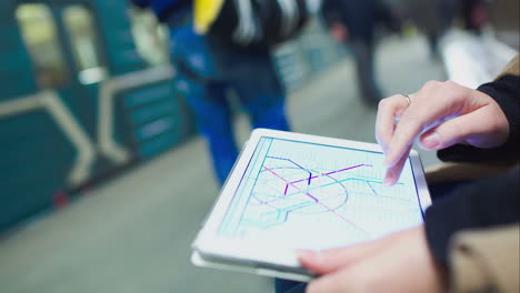 Woman-searching-station-on-underground-map-using-touch-pad