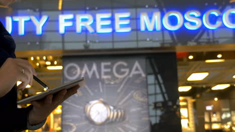 Woman-with-pad-on-escalator-in-Duty-Free-Moscow