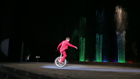Artista-De-Circo-Masculino-Montando-Un-Monociclo-Durante-La-Actuación
