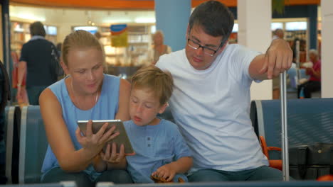 Familia-Esperando-La-Salida-Con-Tablet-Pc