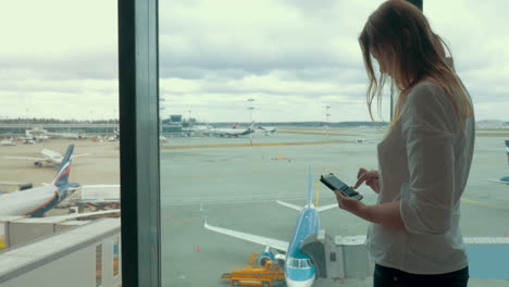 Mujer-Con-Teléfono-Inteligente-En-El-Aeropuerto