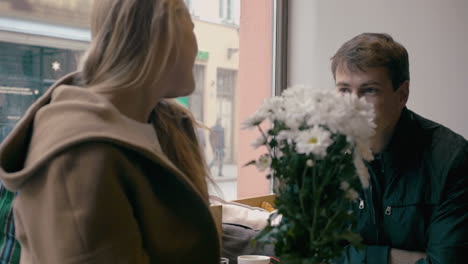 Loving-couple-looking-at-each-other-in-cafe