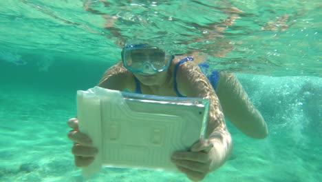 Woman-diving-with-pad-to-make-a-good-underwater-shot
