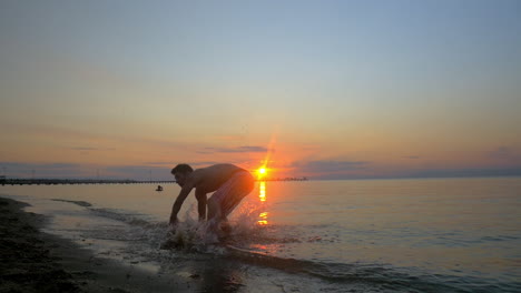Sportler-Macht-Akrobatische-Tricks-Am-Strand-Bei-Sonnenuntergang