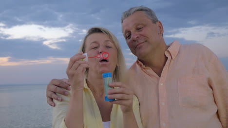 Glückliches-älteres-Paar-Bläst-Seifenblasen-Am-Strand