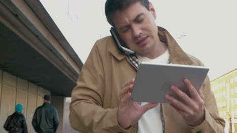 Vielbeschäftigter-Mann-Mit-Smartphone-Und-Tablet-Im-Freien