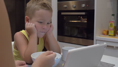 Mother-feeding-child-while-he-watching-tablet-PC