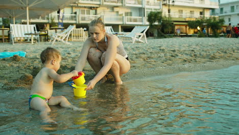 Kleiner-Junge-Und-Seine-Mutter-Spielen-Am-Strand