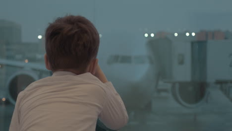 Curious-boy-looking-at-plane-while-waiting-for-the-flight