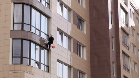 Man-washes-the-windows-of-office-building-1
