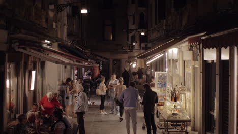 In-Der-Nacht-Venedig-Italien-Straße-Mit-Fußgängern-Und-Straßencafés