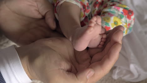 Dad-holding-baby-feet-in-hands