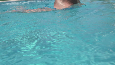 A-boy-in-blue-goggles-swimming-in-an-open-pool