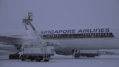 Plane-de-icing-before-departure-in-winter-evening