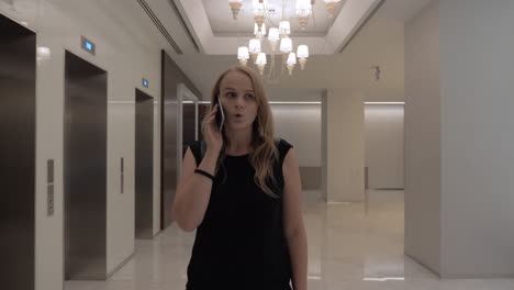 Woman-talking-on-the-phone-in-hotel-hall