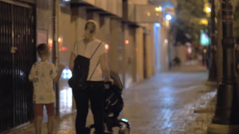 Mother-with-two-children-in-the-street-of-evening-city