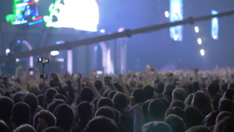 Concert-audience-with-hands-up-and-bright-stage-lights