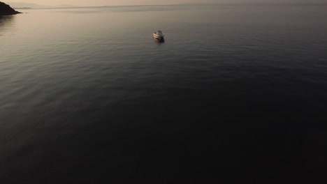 Aerial-view-of-empty-boat-in-quiet-sea-at-sunset
