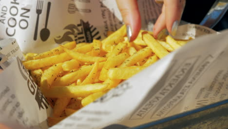 Mujer-Tomando-Un-Refrigerio-Con-Papas-Fritas-Al-Aire-Libre