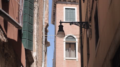 Una-Farola-Montada-En-La-Pared-En-Una-Calle-Estrecha-De-Venecia