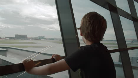 Young-traveller-likes-watching-departing-planes-at-the-airport