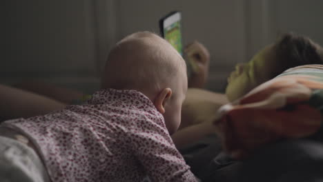 Baby-girl-is-attracted-with-brothers-tablet-computer