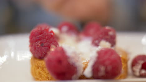 Enjoying-appetizing-dessert-with-fresh-raspberries