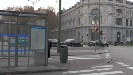 Senior-woman-walking-to-bus-stop-at-Plaza-de-Cibeles-in-Madrid-Spain