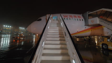 Flugzeuge-Der-Hainan-Airlines-Mit-Treppen-In-Regnerischer-Nacht