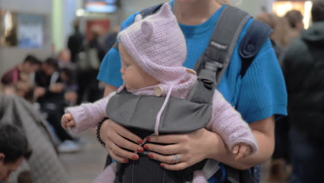 Süßes-Kleines-Mädchen-In-Einer-Babytrage-Am-Flughafen