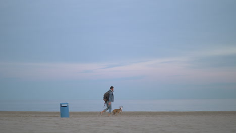 Mann-Geht-Mit-Dem-Hund-Am-Strand-Spazieren