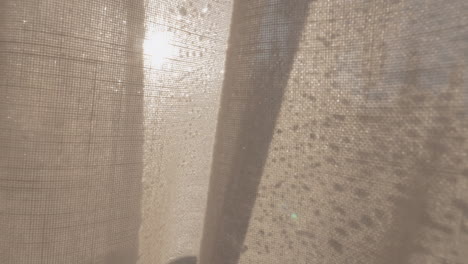 Window-with-morning-condensation-and-light-curtain