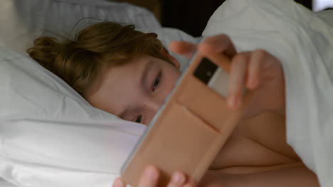 Teenager-in-bed-with-gadget