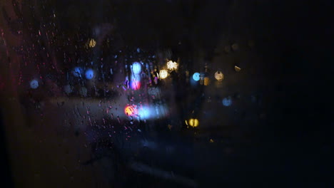 View-of-city-through-wet-and-weepeing-car-window