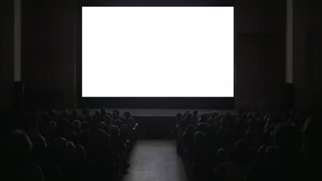 Espectadores-En-Una-Sala-De-Cine-Oscura-Con-Pantalla-En-Blanco.
