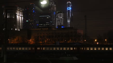 Tren-De-Pasajeros-Pasando-Por-La-Ciudad-Por-La-Noche