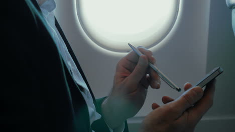 Businessman-using-smart-phone-during-the-flight