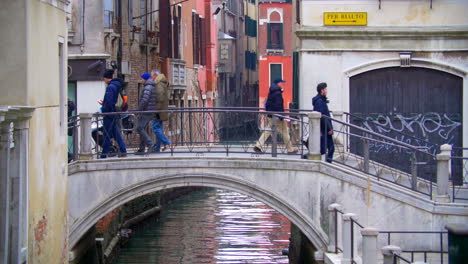 Gente-Cruzando-El-Puente-Sobre-El-Canal-De-Agua-En-Venecia-Italia