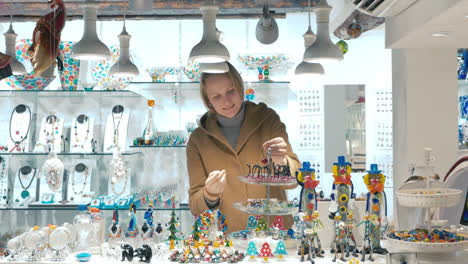 Woman-tourist-choosing-souvenirs-in-Venetian-shop