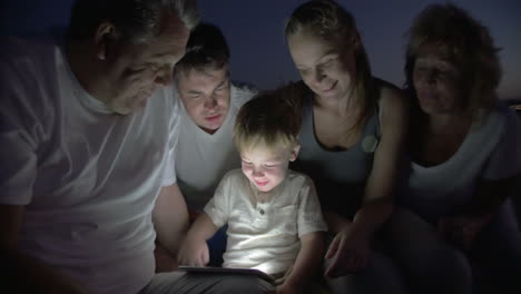 Große-Familie-Schaut-Sich-Eine-Gute-Nacht-Geschichte-Auf-Einem-Tablet-PC-An