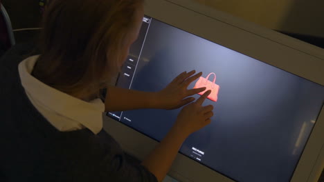 Frau-Betrachtet-3D-Modell-Einer-Tasche-Auf-Einem-Großen-Touchscreen