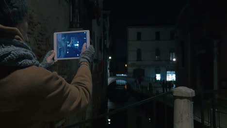 Woman-with-pad-taking-shots-of-Venice-canal-at-night