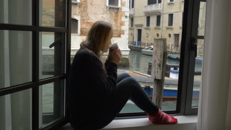 Woman-with-tea-enjoying-scene-from-the-window