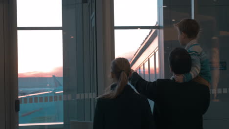 Parents-with-son-looking-at-planes-through-the-window