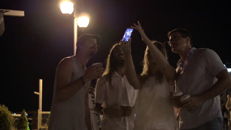 Amigos-Haciendo-Selfie-Móvil-En-La-Calle-Nocturna