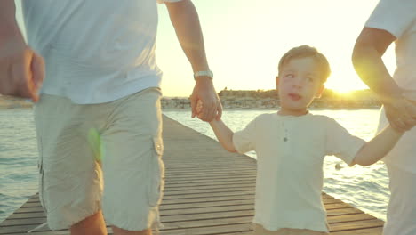 Grandparents-with-grandchild-on-the-pier-at-sunset