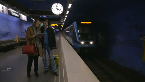 Young-people-with-pad-and-suitcase-in-subway