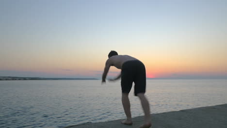 Man-doing-somersault-while-jumping-into-sea