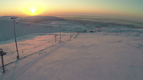 Pista-De-Esquí-Y-Colinas-Nevadas-Al-Atardecer-Vista-Aérea