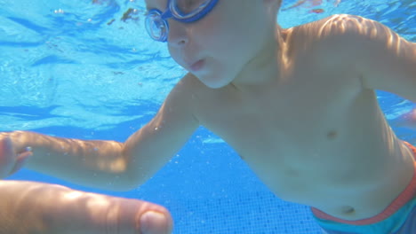 Un-Niño-Nadando-Bajo-El-Agua-En-La-Piscina